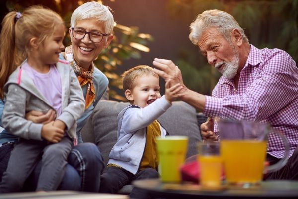 Cheerful grandchildren spending good and funny time with their happy grandparents.