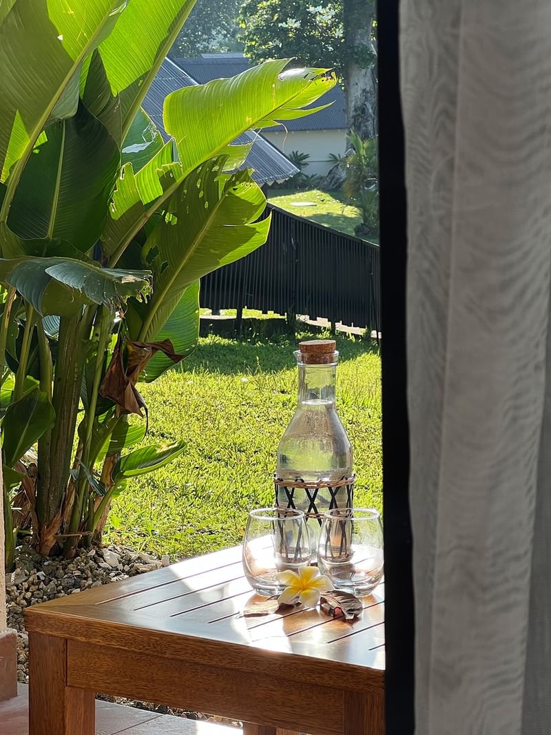 Garden View Room patio with wooden table and chair at Warwick Le Lagon - Vanuatu, Efate.