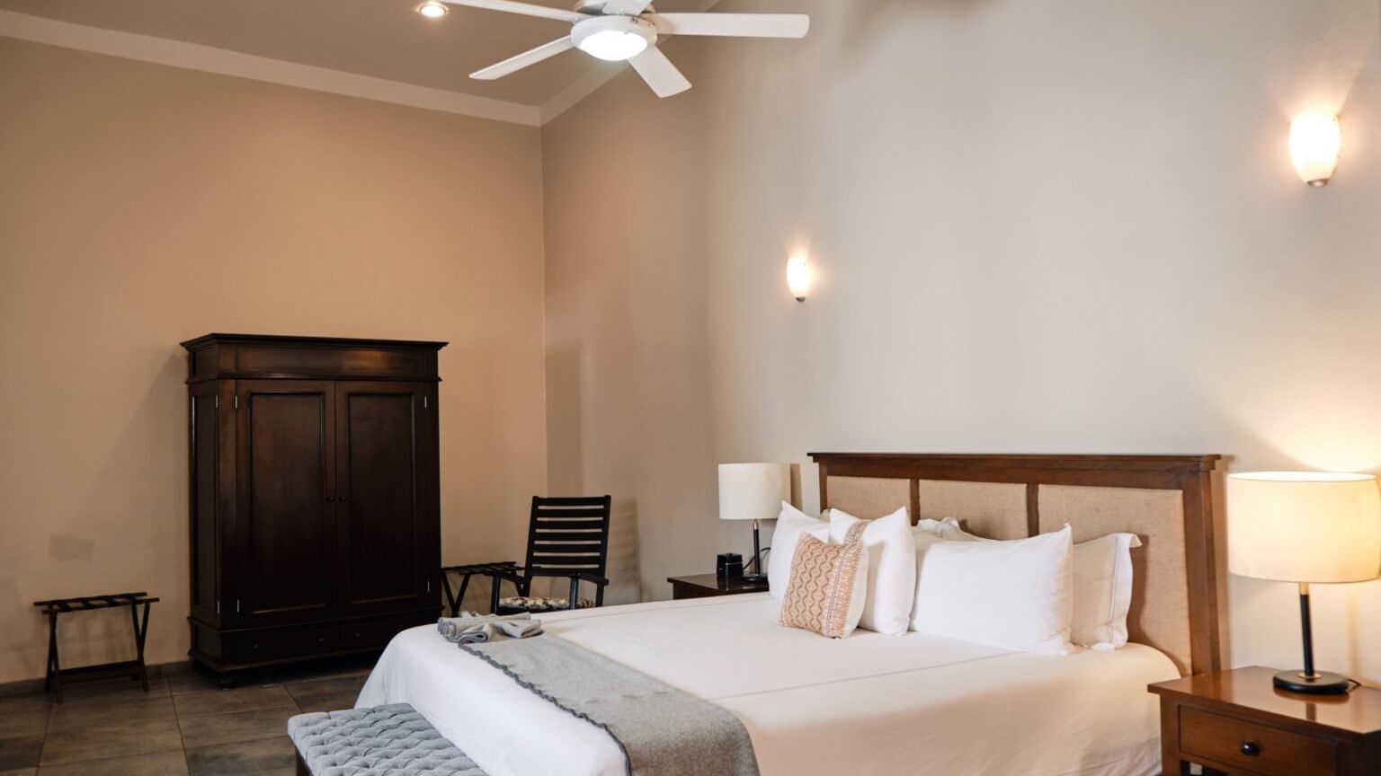Comfortable room featuring a bed, a wardrobe, and a ceiling fan at Curamoria Collection