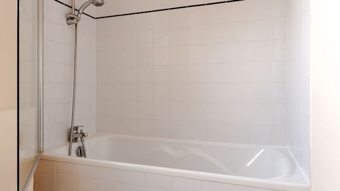 Bathroom with a bathtub in a room at Hotel Le Savoy