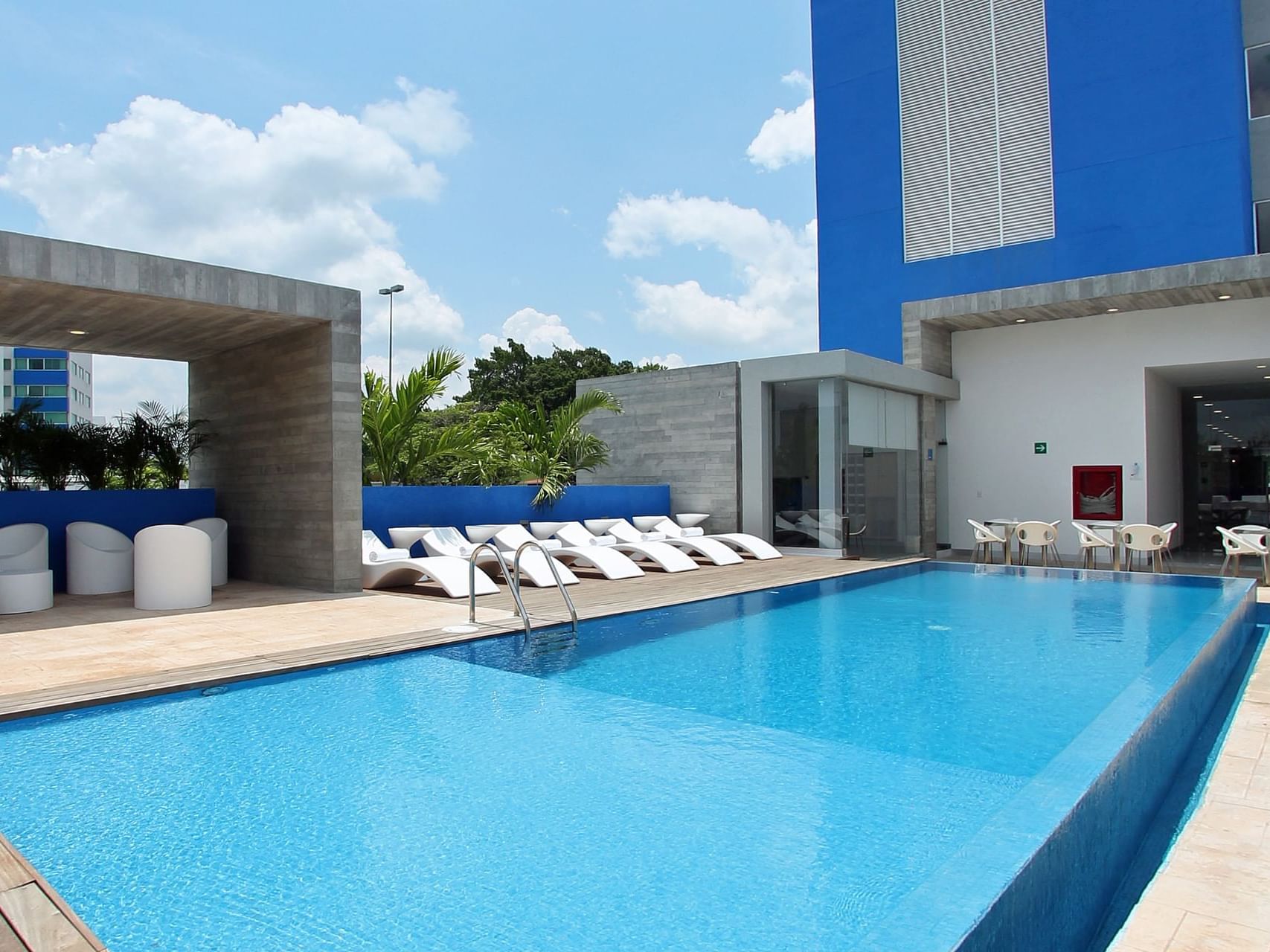 Sunbeds by the outdoor swimming pool area at One Hotels