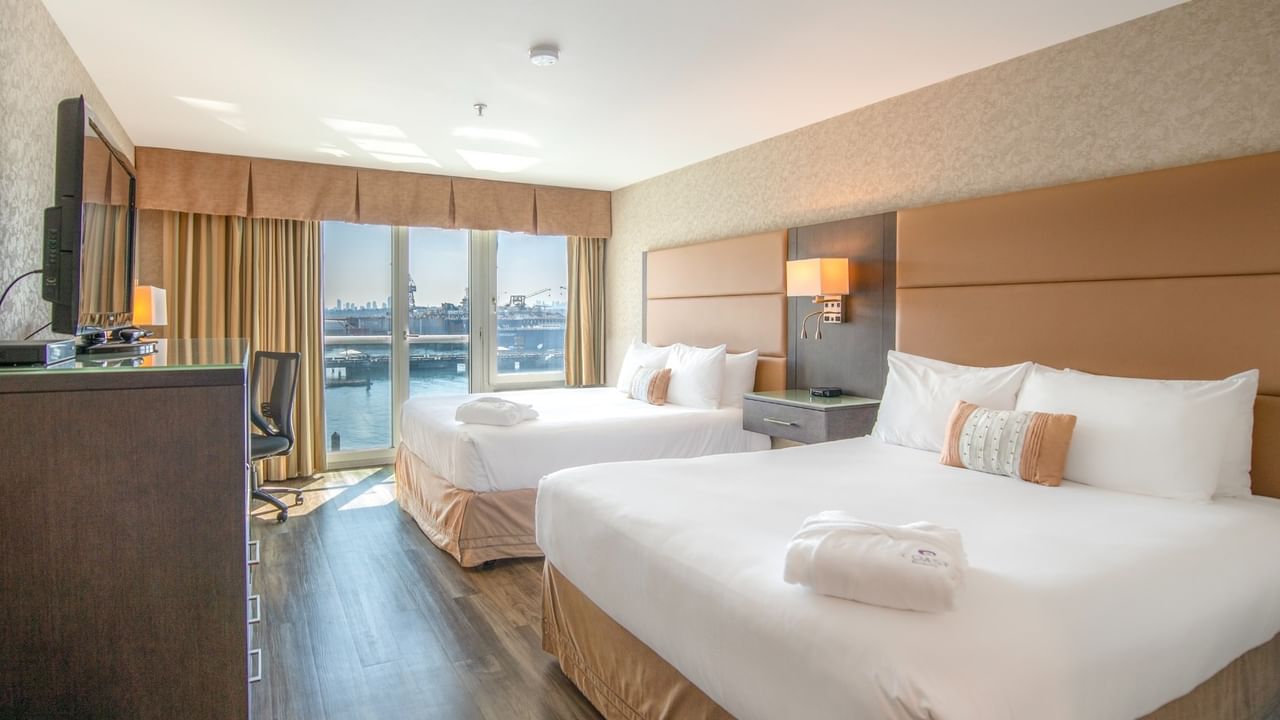 Coast Premium Two Queens with Two hotel beds, a wooden dresser, a TV, and a large window at Coast Lonsdale Quay Hotel