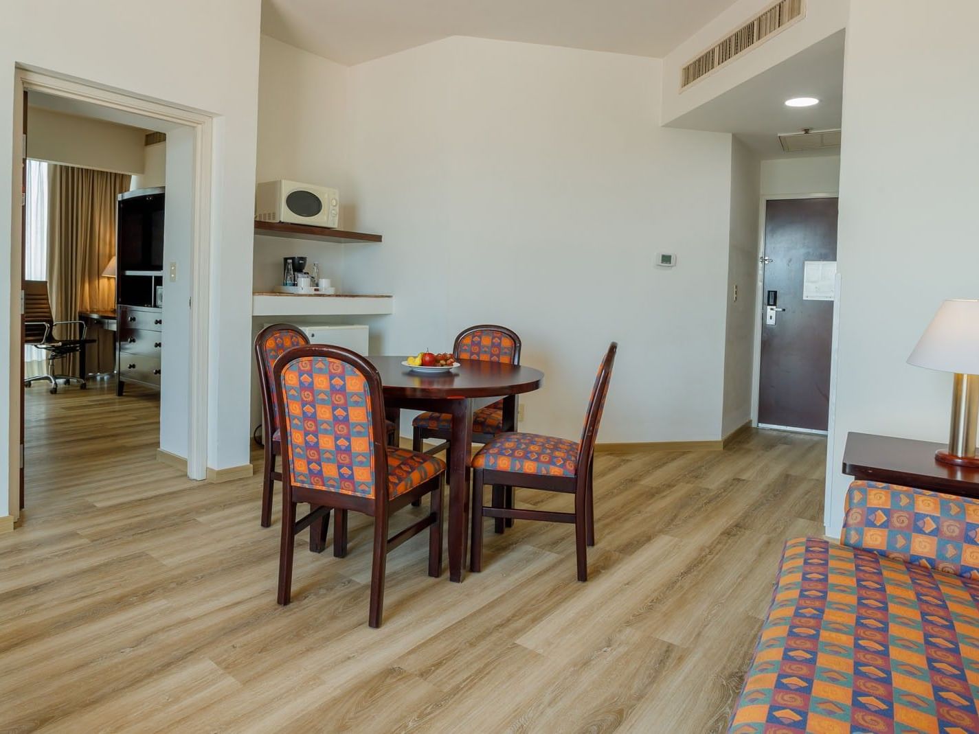 King Junior Suite living area featuring a dining table with patterned chairs and a kitchen nook at Camino Real Pachuca