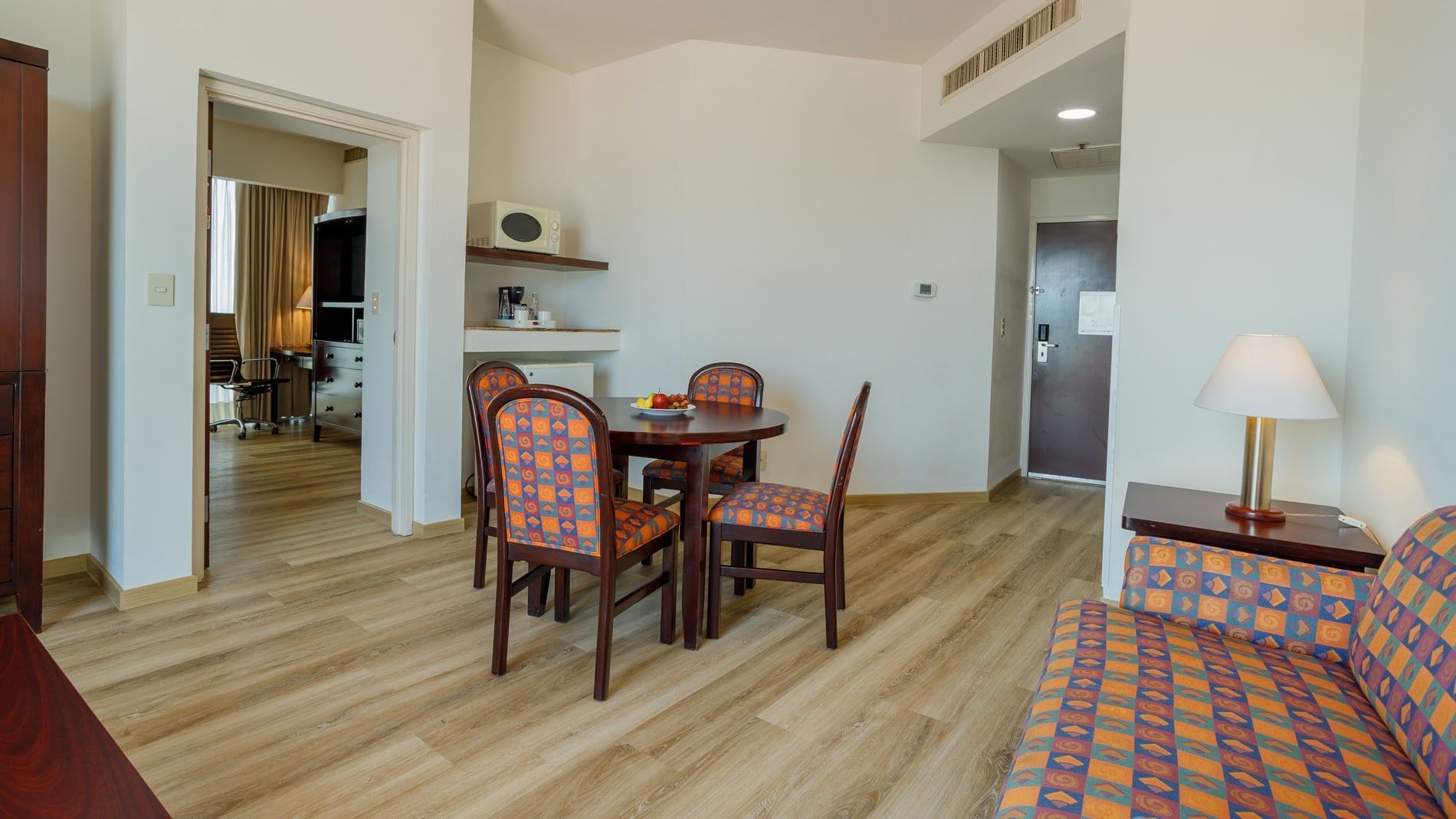 King Junior Suite living area featuring a dining table with patterned chairs and a kitchen nook at Camino Real Pachuca
