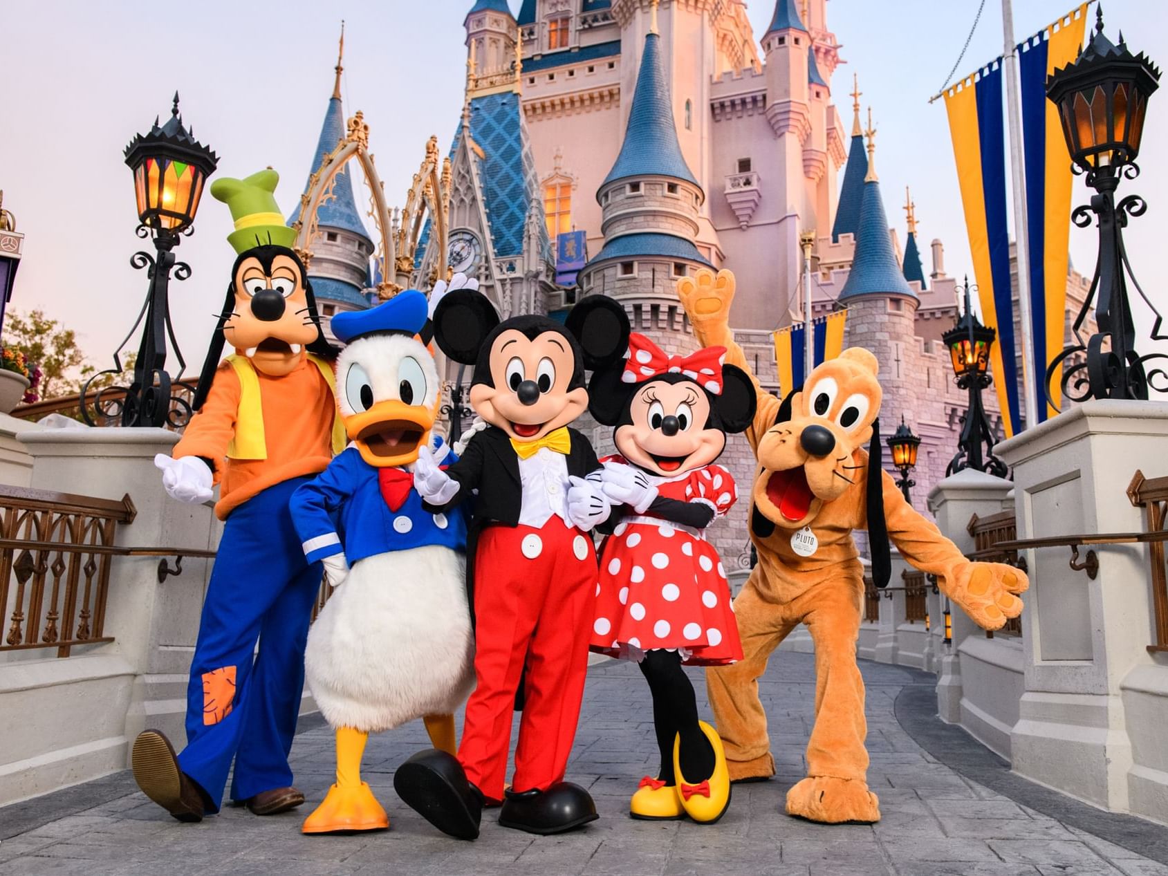 Disney characters posing in front of Walt Disney World’s Magic Kingdom near Lake Buena Vista Resort Village & Spa