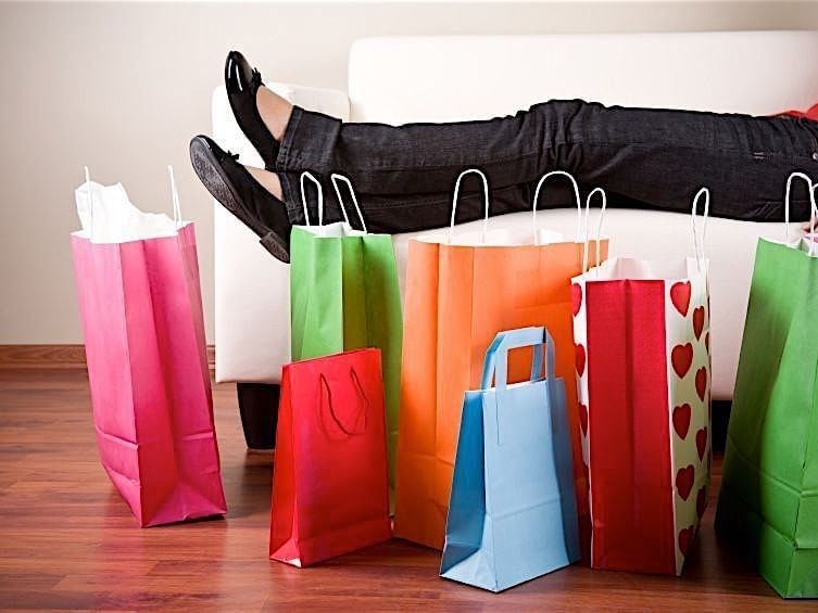 shopping bags next to couch and womans legs