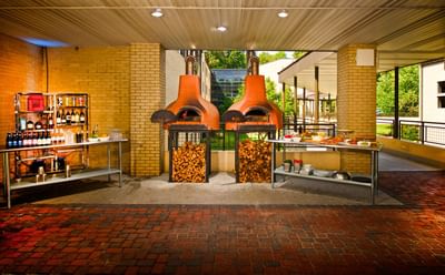 The covered patio at the Bolger Center, featuring two large brick pizza ovens and a buffet setup