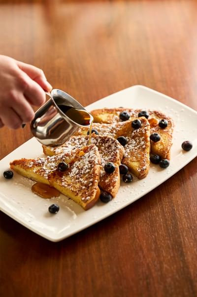 Pouring honey on French toast at The IowaStater Restaurant