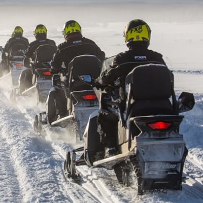 a group of snowmobiles traveling together