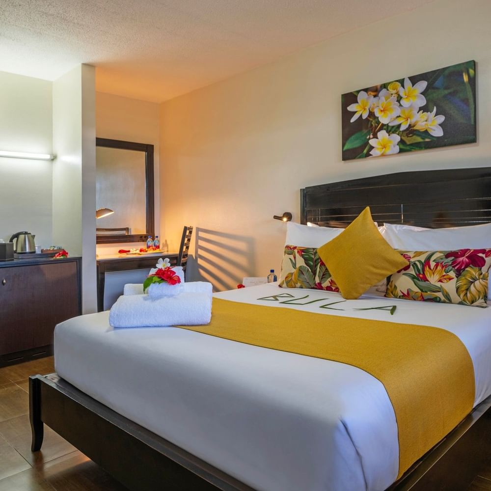 Standard Room with a large bed, tropical decor, and wooden floors at Tokatoka Resort - Fiji International Airport in Nadi.