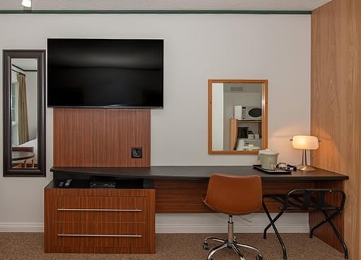 desk,TV and chair in a guest room at Coast Innisfail Hotel