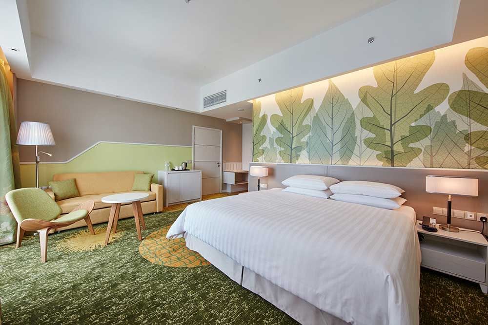 King-size bed and sitting area in a room at Sunway Velocity Hotel