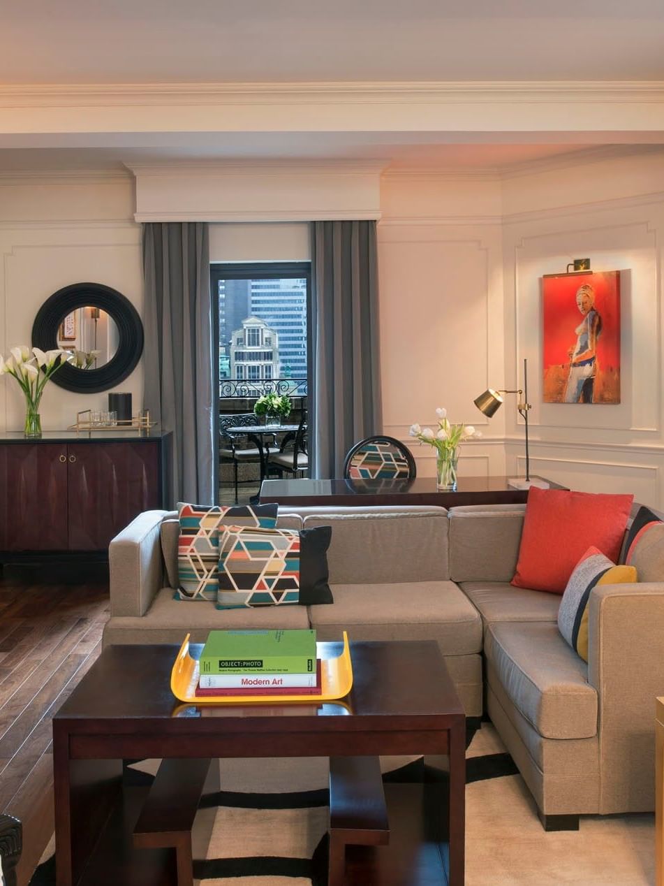 Living area with a grey sectional sofa & colorful pillows, and vibrant red artwork in Modern Art Suite at Warwick New York