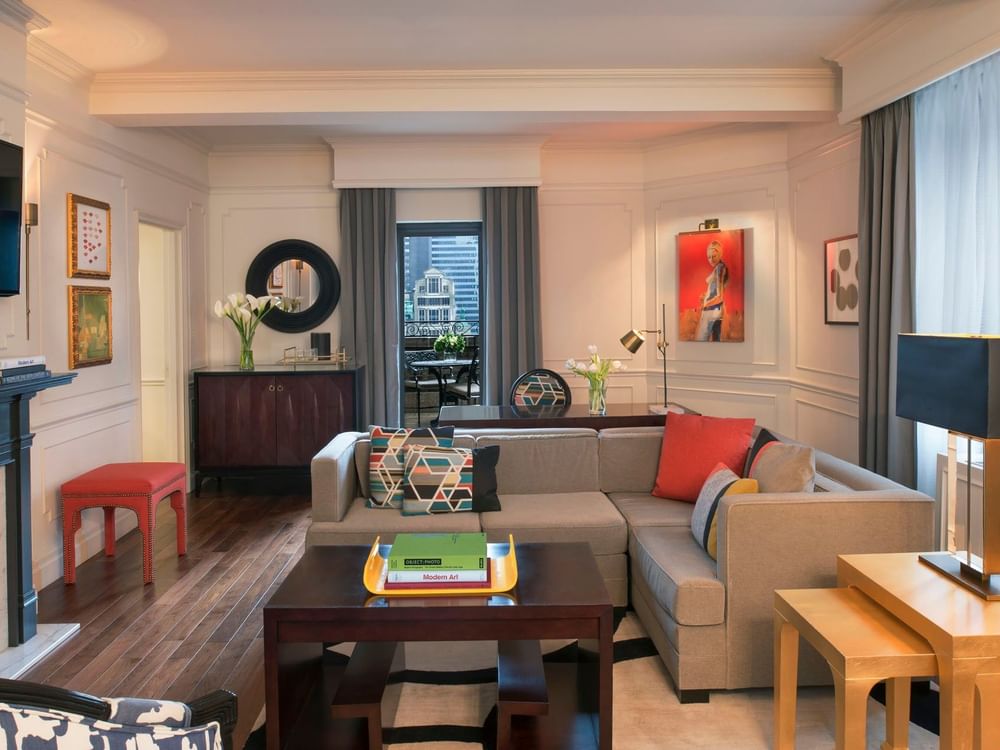 Living area with a grey sectional sofa & colorful pillows, and vibrant red artwork in Modern Art Suite at Warwick New York