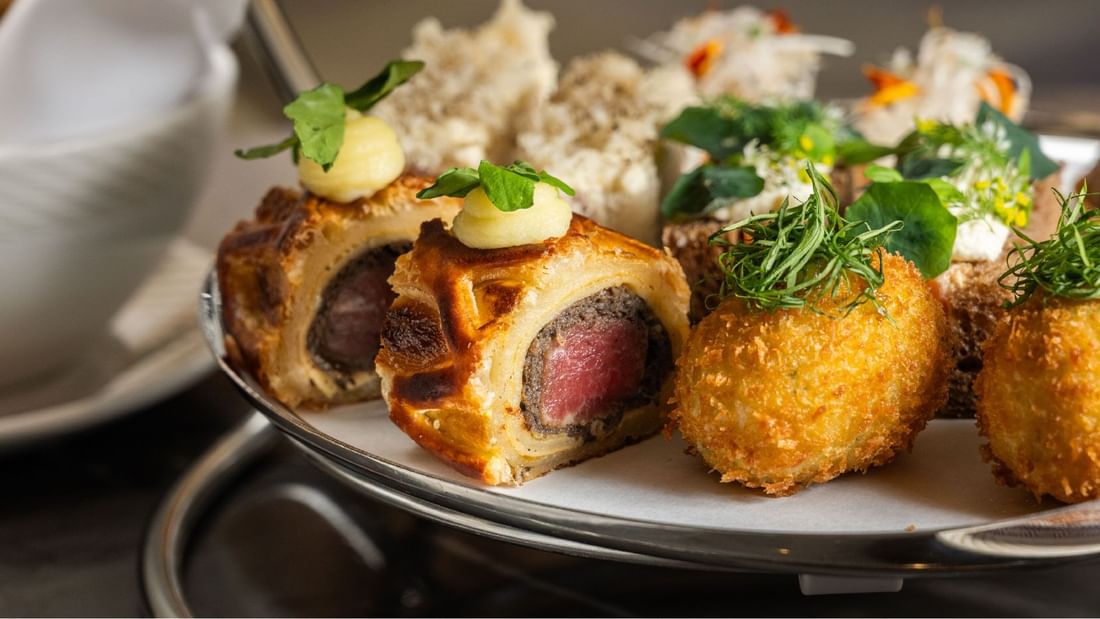 Close-up of a gourmet high tea offering, including beef wellington and crispy bites, served at Sunway Hotel Pyramid