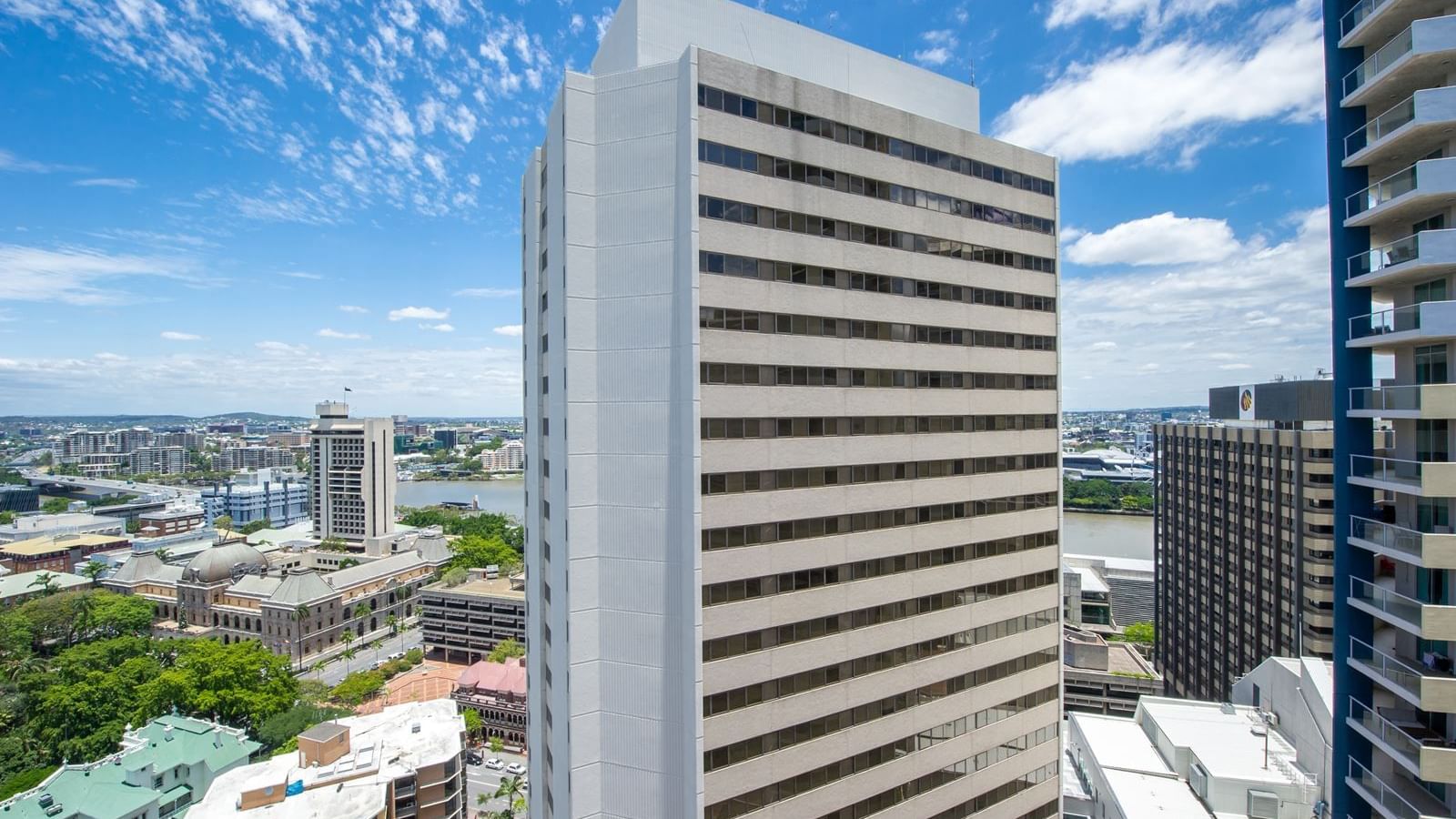 Modern white high-rise building with horizontal window bands under a blue sky at StudentLiving - on Margaret