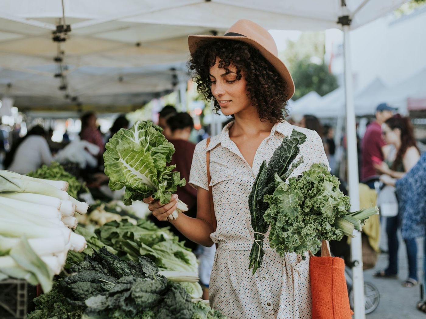 Una señora comprando verduras en Flora Farms cerca de Grand Fiesta Americana