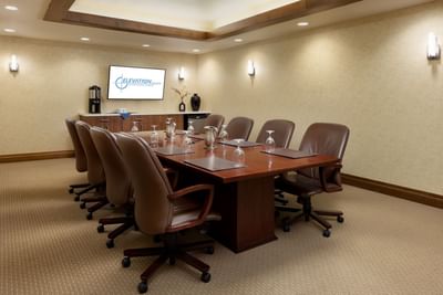 Large conference table with leather chairs in a meeting room with a screen at Elevation Resort Spa