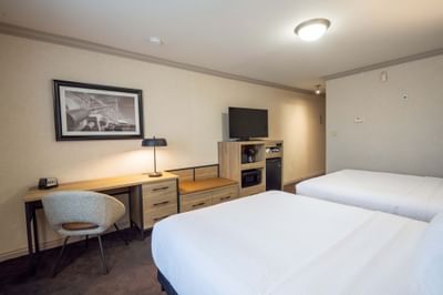 Standard Room with bed, TV, work desk and wall art at Sandman Hotel & Suites Winnipeg Airport