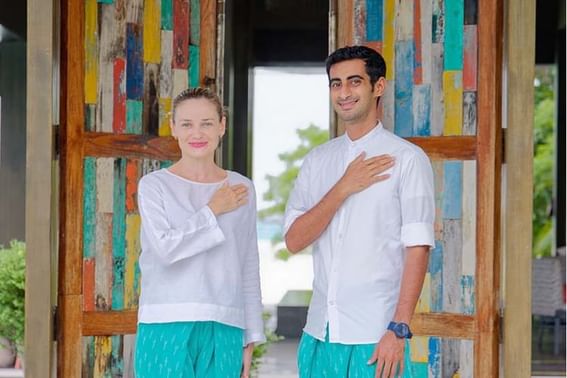 Two people standing by a colorful wooden door at Grand Park Kodhipparu, Maldives