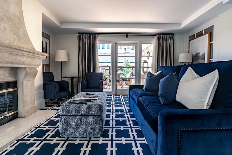 Cozy living area featuring a navy blue sofa, a patterned rug, and a fireplace at El Prado Hotel