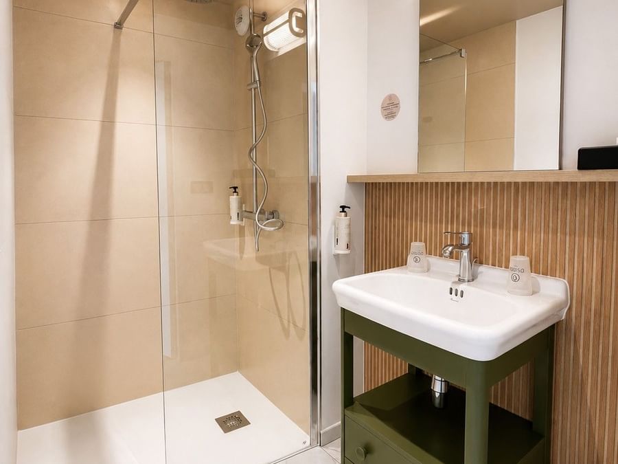Salle de bain moderne avec douche et lavabo à Osmo Hôtel, Chantepie.