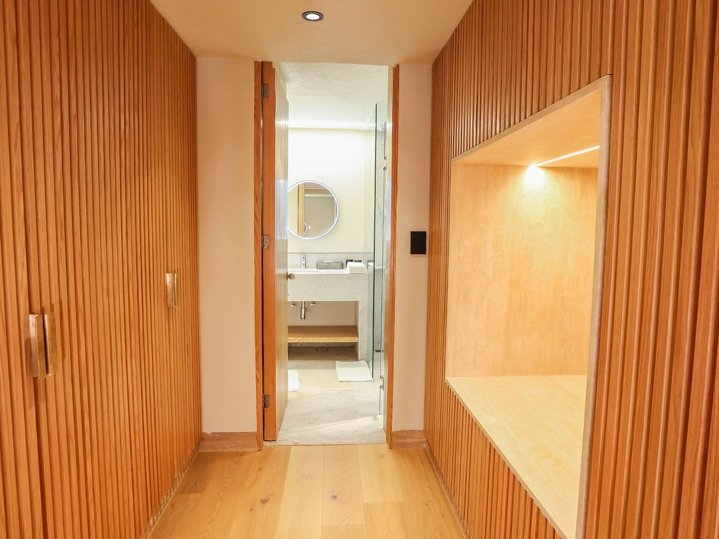 Wooden hallway leading to a bathroom with a mirror at Camino Real Polanco Mexico in Ciudad de Mexico.