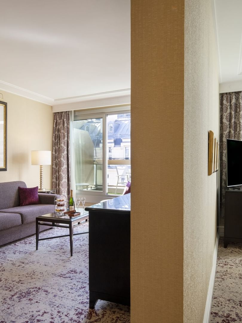 Grey sofa by a glass coffee table near a TV stand in Executive Suite with Terrace at Warwick Paris Champs Elysées