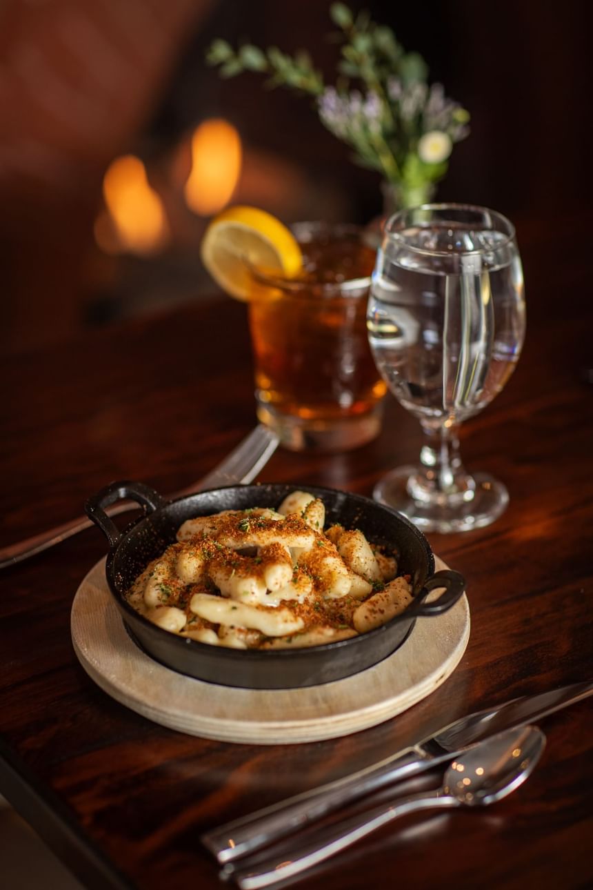 Cast iron dish of seasoned gnocchi served with drinks at Regency Restaurant in Portland Regency Hotel & Spa