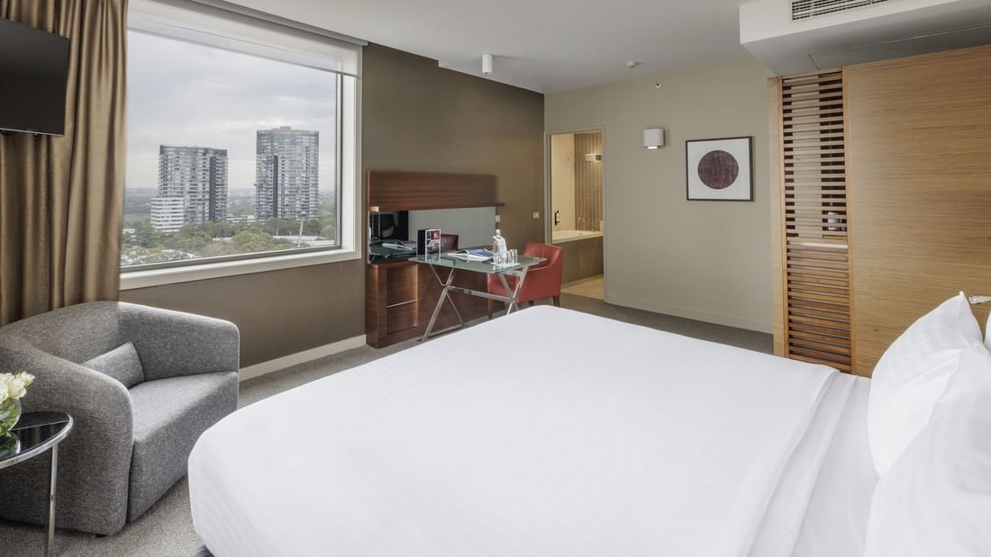 Work desk by the window facing bed in Pullman Deluxe King Room at Pullman Sydney Olympic Park