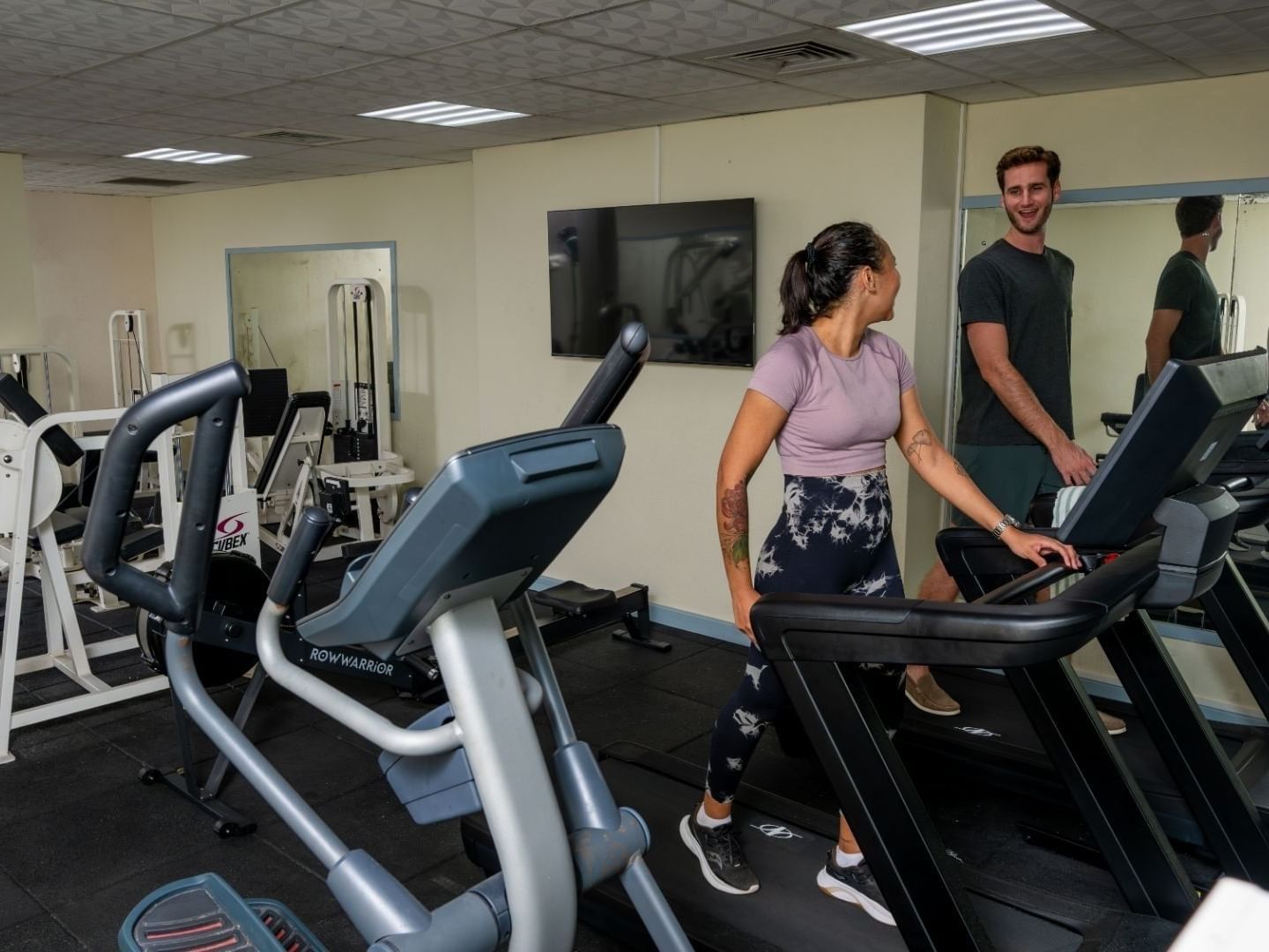 People using treadmills in a gym with modern equipment at Savannah Beach Hotel.