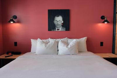 The Crate XL room at The Gaythering offers a cozy king bed, quirky wall art, soft lighting, and minimalist wood accents