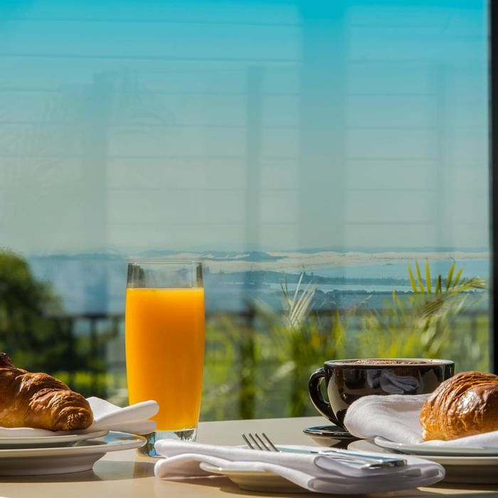 Breakfast croissants, fresh juice and coffee served on a table outdoors overlooking the city view at Mercure Charlestown