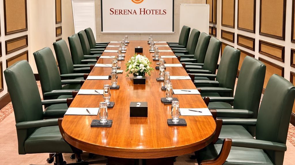 Intimate oval meeting table with floral centerpiece and garden view for conferences in Asia at Serena Hotels & Resorts