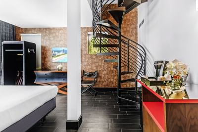 King-size bed, TV, and a spiral staircase to the rooftop in Premium King with Rooftop Terrace at Fairwind Hotel Miami