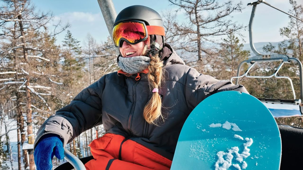 A snowboarder smiles while getting ready to jump off the ski lift at a ski hill near Canmore.