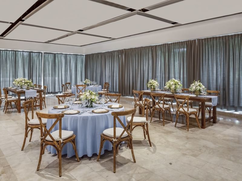 Cozumel meeting room set with elegant round and long tables and white floral arrangements at Fiesta Americana