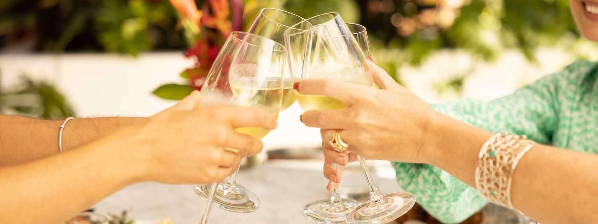 People toasting wine glasses over dining table in Aluco restaurant and Bar at Pullman Port Douglas