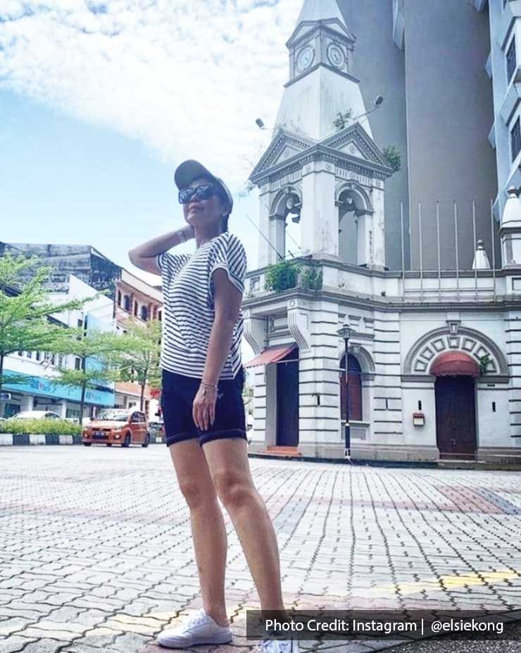 A lady was striking a pose and taking a picture with the Taiping Colonial Tower - Lexis Suites Penang