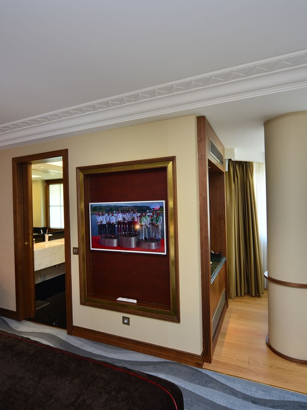 Office chair by a desk surrounding a pillar under a wall-mounted TV in Executive Room at Warwick Ankara