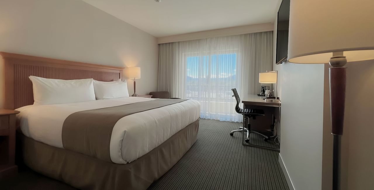 Hotel room with King bed, work desk, chair, and TV