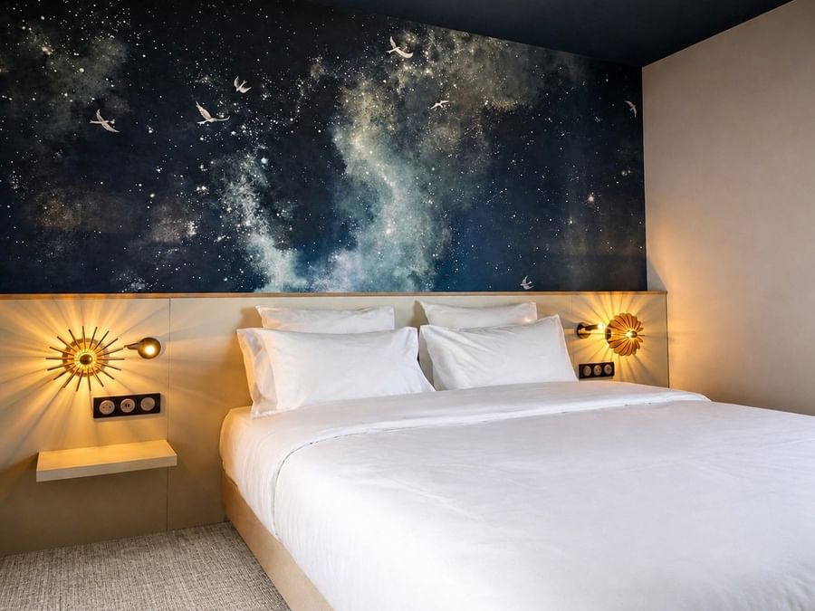 Chambre Junior Suite avec lit blanc et mur céleste étoilé à Osmo Hôtel, Chantepie.