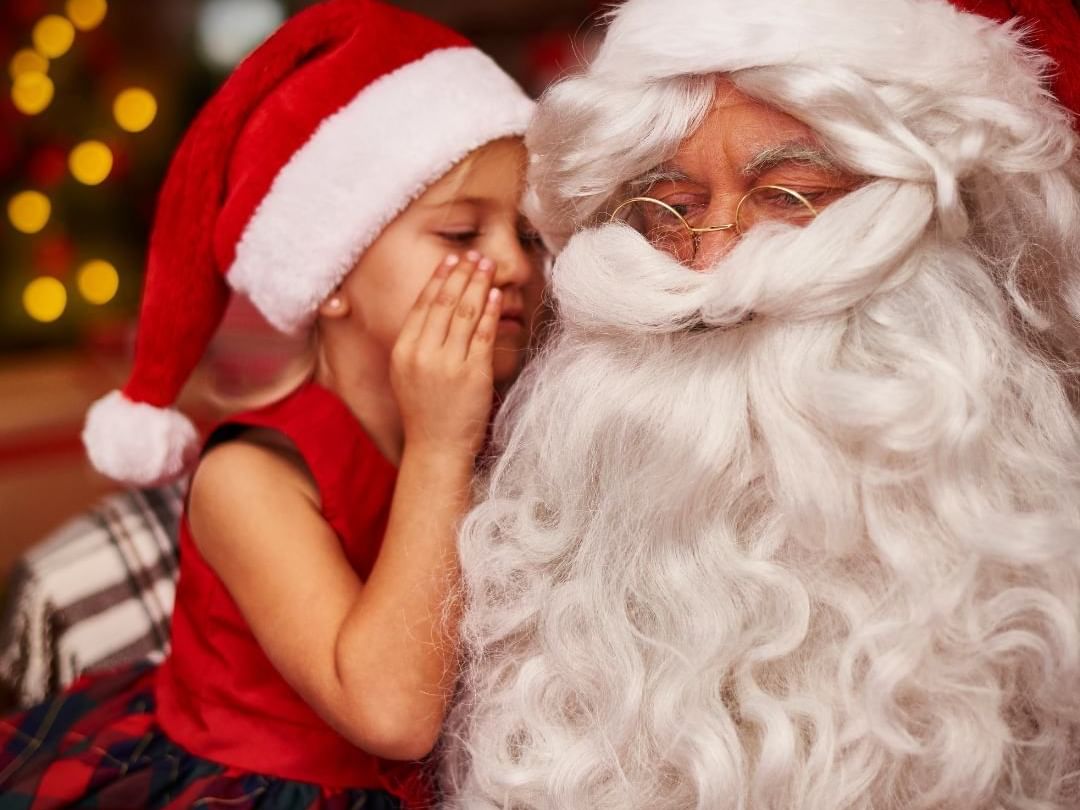 Little girl whispering to Santa 