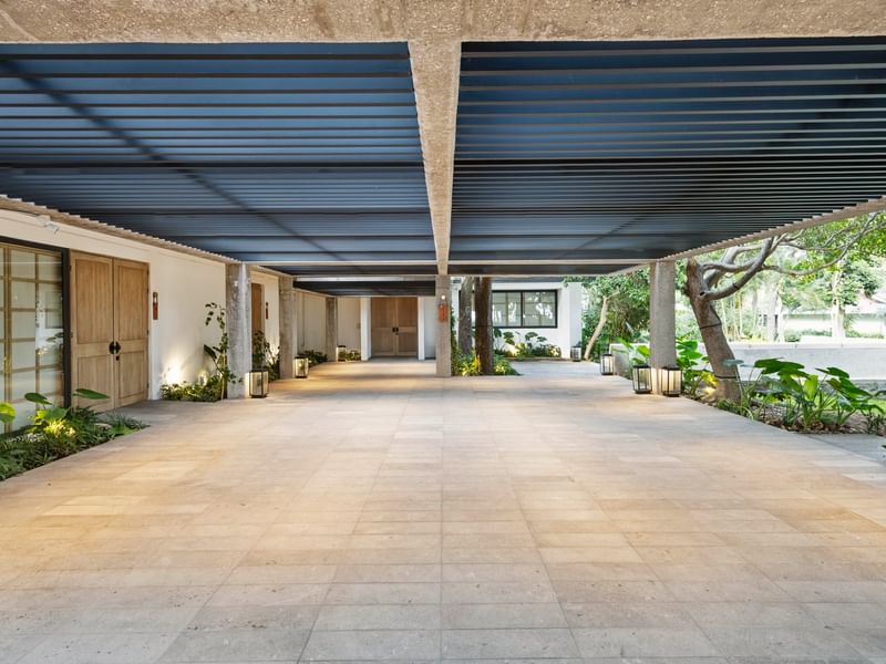 Wide tiled walkway with blue canopy and greenery at Grand Fiesta Americana Sumiya Cuernavaca.