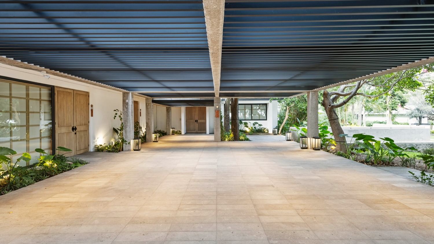 Wide tiled walkway with blue canopy and greenery at Grand Fiesta Americana Sumiya Cuernavaca.