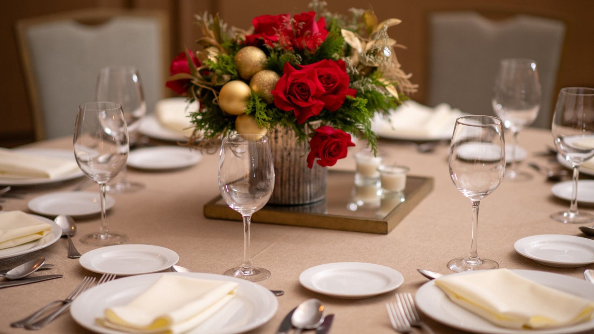 Salon Duque dining table featuring red roses, gold ornaments, and fine glassware at Quinta Real Monterrey