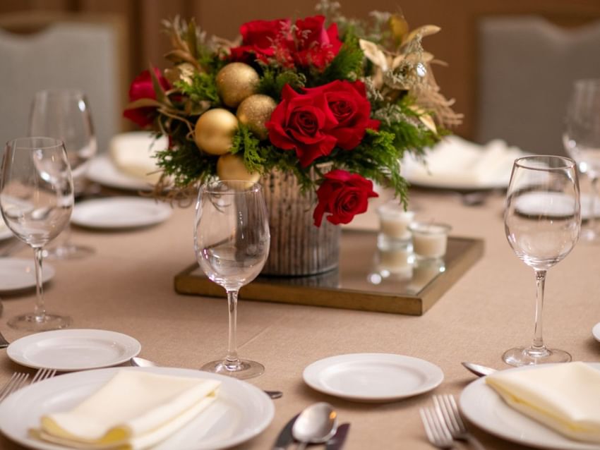 Elegant table setting in Salon Duque featuring a centerpiece of red roses and gold decorations at Quinta Real Monterrey