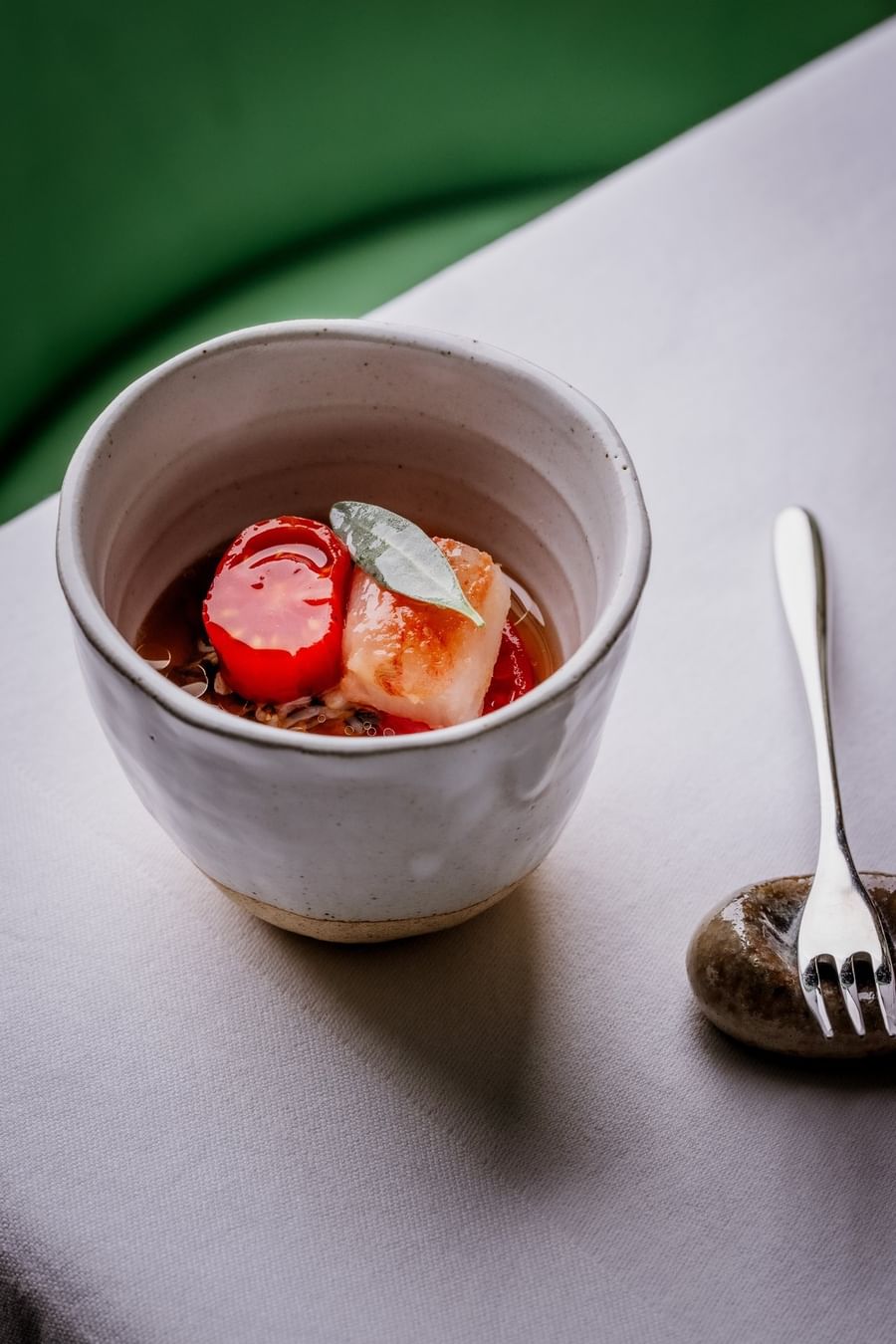 Fresh appetizer in a ceramic bowl placed by a small fork at The Capital Hotel, Apartments and Townhouse