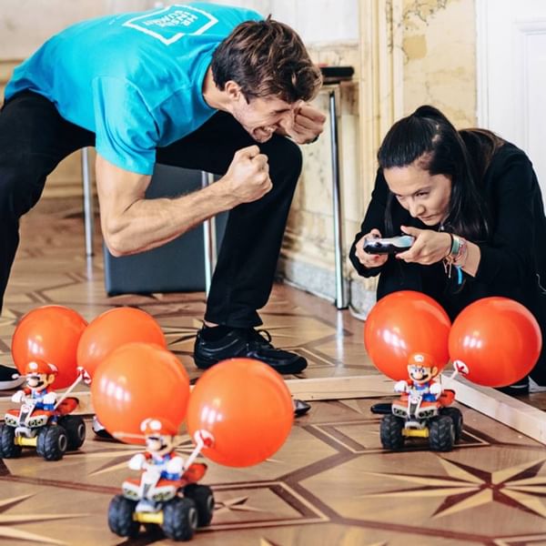 Two people playing with toy cars at Falkensteiner Hotels