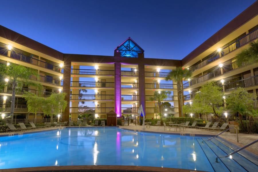 The exterior of Rosen Inn Lake Buena Vista at twilight, with lights glowing around the pool.